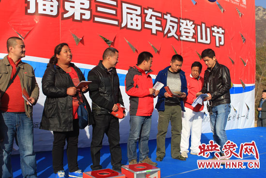 河南交通廣播工作人員為獲得獎品的車友發獎