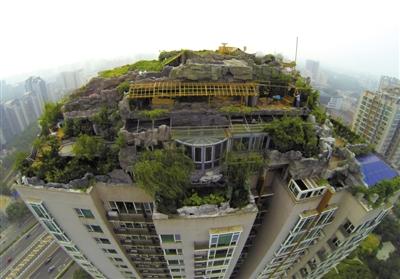　　昨日，身穿橘黃色馬甲的工作人員在人濟山莊樓頂拆除違章建筑。新京報記者 吳江 攝