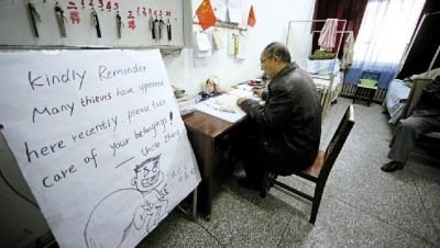 張大爺在門衛(wèi)室里工作，旁邊是紅爆網(wǎng)絡(luò)的溫馨提示牌記者