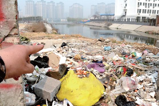 金水河長江路橋下河水發(fā)臭，水邊堆放眾多垃圾