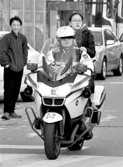 7日，首爾，警察將一名考生送抵考場。新華社發