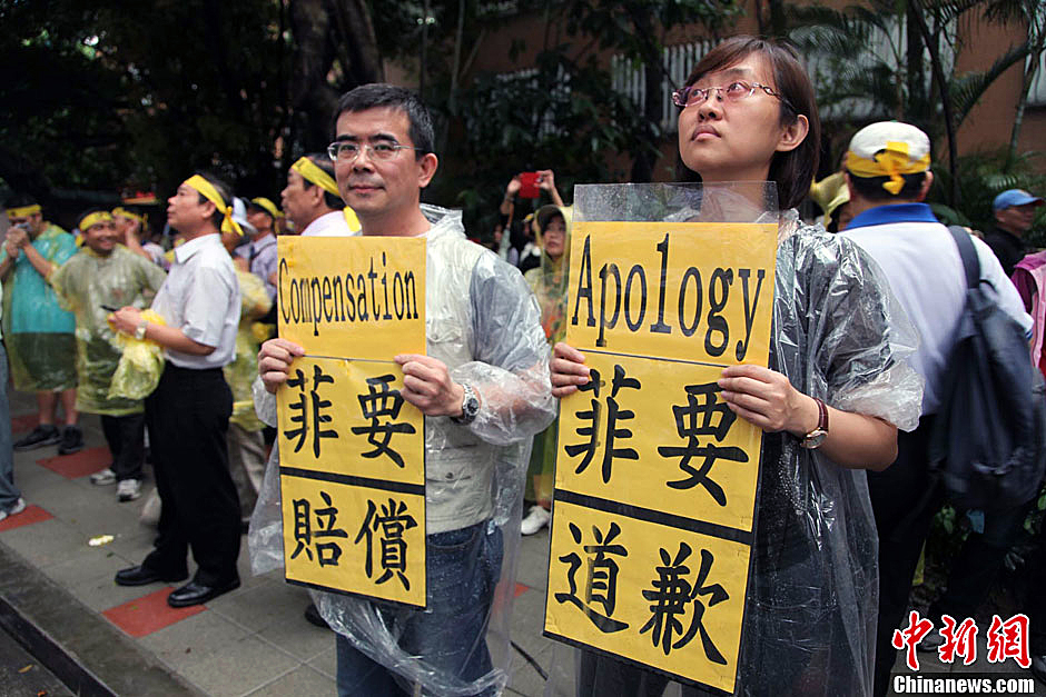 　圖為當天下午，當臺灣數百漁民在馬尼拉經濟文化辦事處前抗議時，有兩名年輕人手持標語，在路邊聲援。中新
