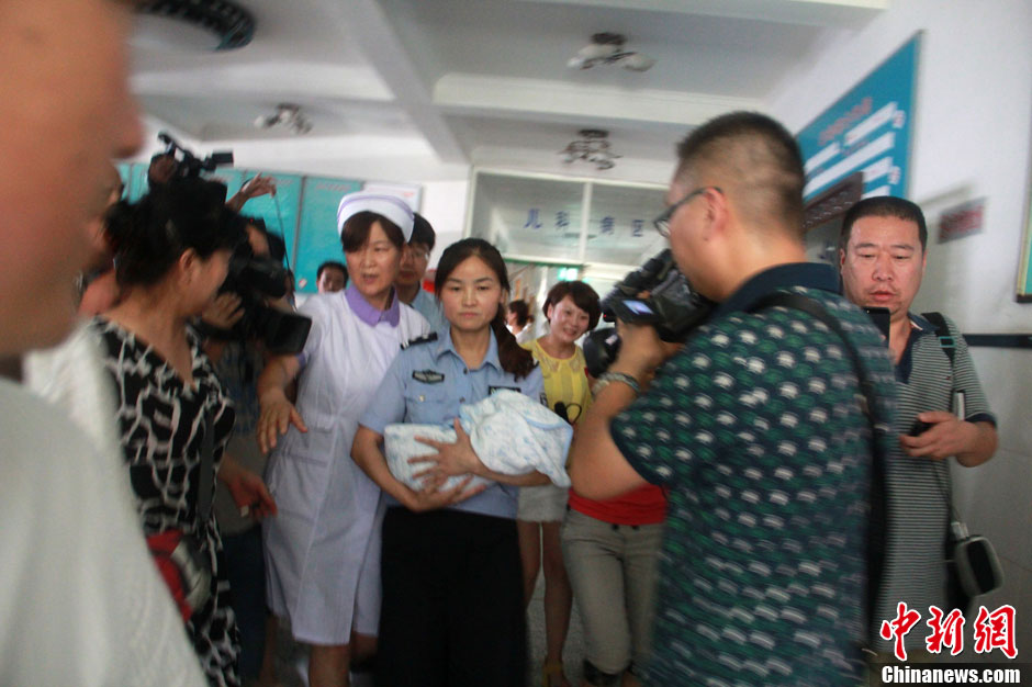 圖為當地民警懷抱獲救嬰兒進入富平婦幼保健院。張一辰 攝