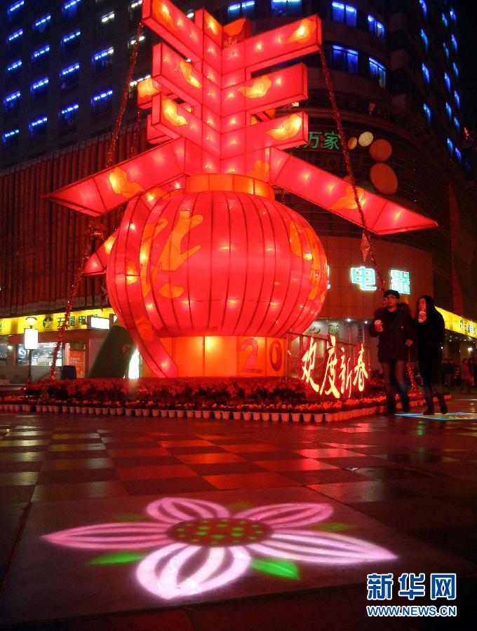 　1月30日晚，市民從蘇州市石路銀河廣場上大型“春”字彩燈景觀旁經(jīng)過。