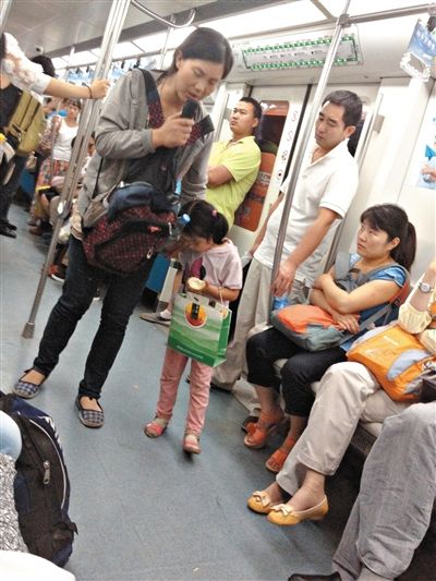 6月27日，舒馨帶一女孩在地鐵十號線行乞。她因被疑帶多個不同小孩乞討被警方搜尋。新京報記者 申志民 攝