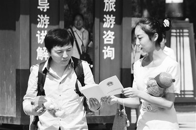 9月13日，西安臨潼華清池景區服務人員向游客介紹《旅游法》。