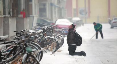 小伙子跪在樓前，一直抬頭看著樓上。 孫立國(guó)/攝
