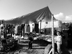 黎巴嫩一敘利亞難民營(yíng)，難民支起攤鋪賣衣服掙錢。