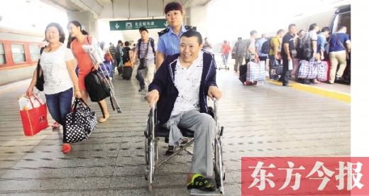 李剛手術(shù)后歸來(lái)，在車(chē)站工作人員幫助下走出鄭州火車(chē)站站臺(tái)  東方今報(bào)首席記者 張曉冬 攝