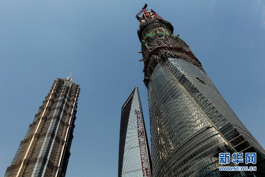 4月11日，正在建設中的“上海中心”（右）的高度已超過金茂大廈（左）和上海環球金融中心（中）。