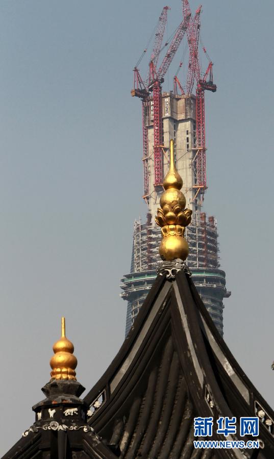 正在建設中的“上海中心”與豫園地區的傳統建筑（前）（4月11日攝）。