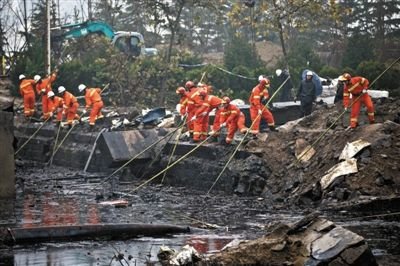 消防員在發現遺體的出事現場周邊搜尋是否還有遺體。