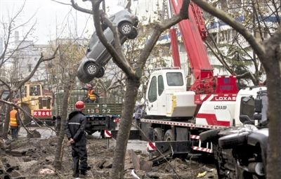輸油管道爆炸后，搶修人員將被炸毀的車輛運出現場。