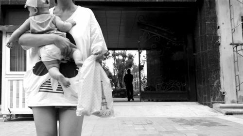 抱著孩子出售人奶的女子。