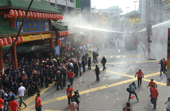 圖為鎮暴警察在吉隆坡的華人聚居地茨廠街向紅衣人噴射水柱