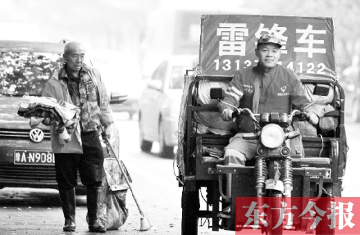 鄭州市商城路，一名環衛工懷抱著剛剛收到的毯子，目送“雷鋒哥”孫德坤離開