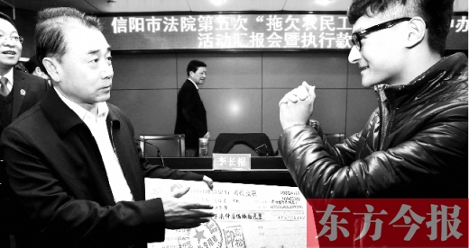 張立勇將依法執行回來的農民工工資發放給案件當事人游昌華，游昌華施以中國傳統作揖禮答謝