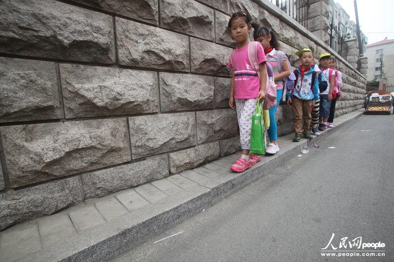 2013年09月11日，濟南運署街上，小學(xué)生走史上“最窄人行道”上學(xué)。圖片來源：CFP