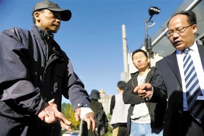 常林鋒在法院外展示雙手，他稱被燙傷的手因刑訊逼供且未得到及時救治