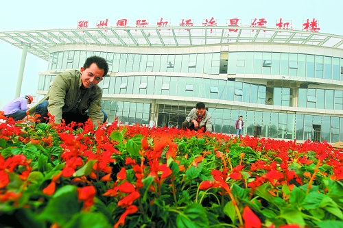 9月23日，工人們正在鄭州國際機(jī)場許昌候機(jī)樓前擺放鮮花。