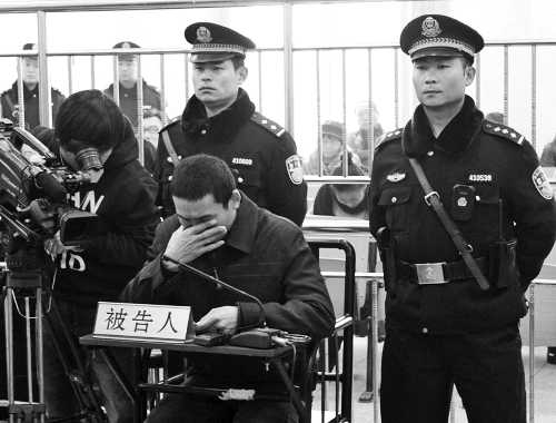 庭審中,29歲的李軍低著頭。