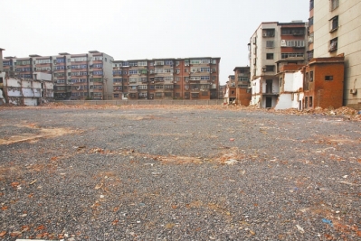 為降塵，旮旯王村拆遷后裸露的地面上鋪了一層石子。
