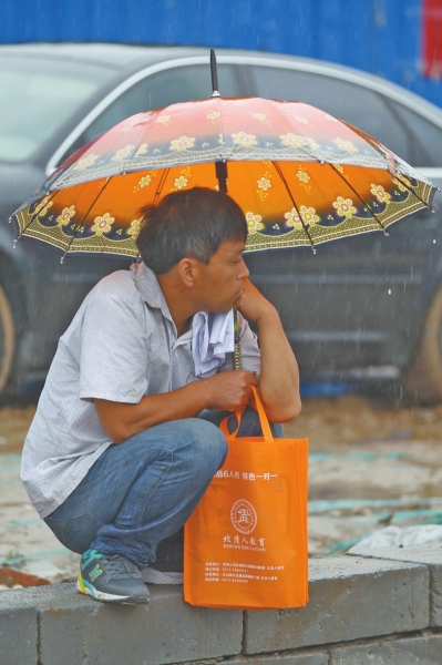 冒雨守在考點(diǎn)門(mén)外牽腸掛肚的家長(zhǎng)