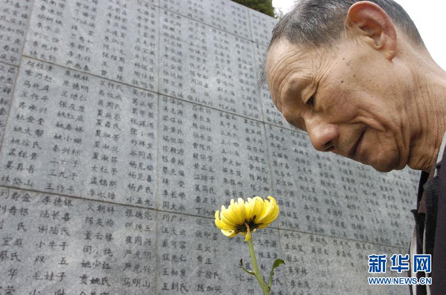 2006年4月5日，74歲的南京大屠殺幸存者佘子清手捧鮮花，祭奠被日軍殺害的母親。