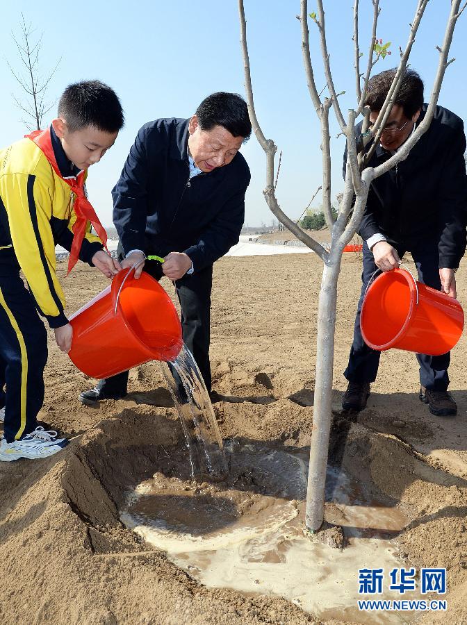 這是習近平同大家一起給剛栽下的樹苗澆水。