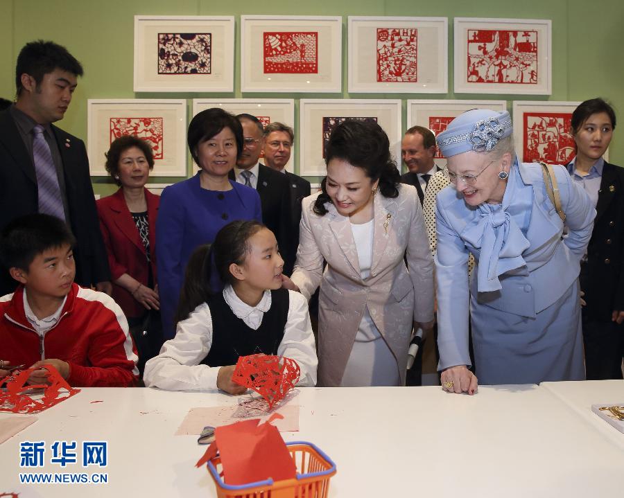 這是彭麗媛和瑪格麗特二世與根據(jù)安徒生童話中人物和情節(jié)制作剪紙的孩子交談。