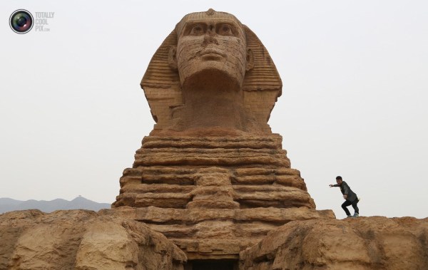 石家莊郊外，一名男子與山寨版獅身人面像合影留念。