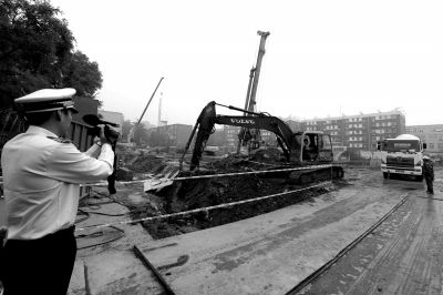 學院南路一科研樓項目有3臺挖掘機違規進行土方作業，被城管隊員當場責令停工。京華時報記者歐陽曉菲攝
