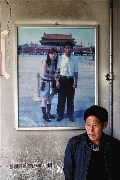 11月14日，承德市平泉縣，潘小梅父母的家，潘小梅父親靠在墻上，身后掛著數(shù)年前他和潘小梅在北京的合影照片。新京報(bào)記者