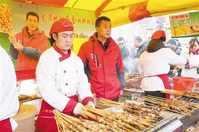 賣羊肉串攤位老板趙山（穿紅衣者）。新京報記者
