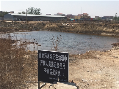 化肥廠滲坑的三分之一經(jīng)過治理，但水質(zhì)仍然呈黃褐色。