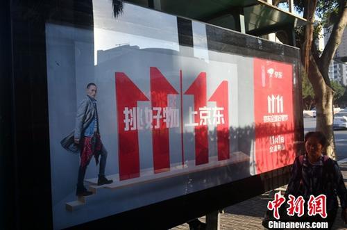 資料圖：11月1日，福州民眾從雙十一廣告牌前經(jīng)過。中新社記者 呂明 攝