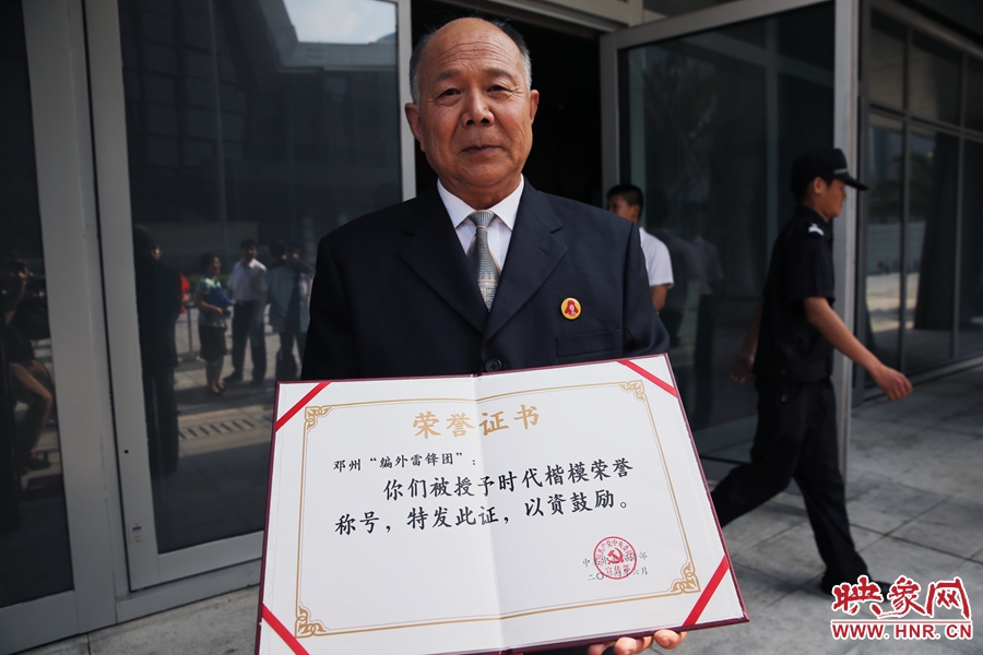 河南鄧州“編外雷鋒團(tuán)”團(tuán)長(zhǎng)宋清梅向眾多記者展示中宣部授予的“時(shí)代楷模”榮譽(yù)證書。