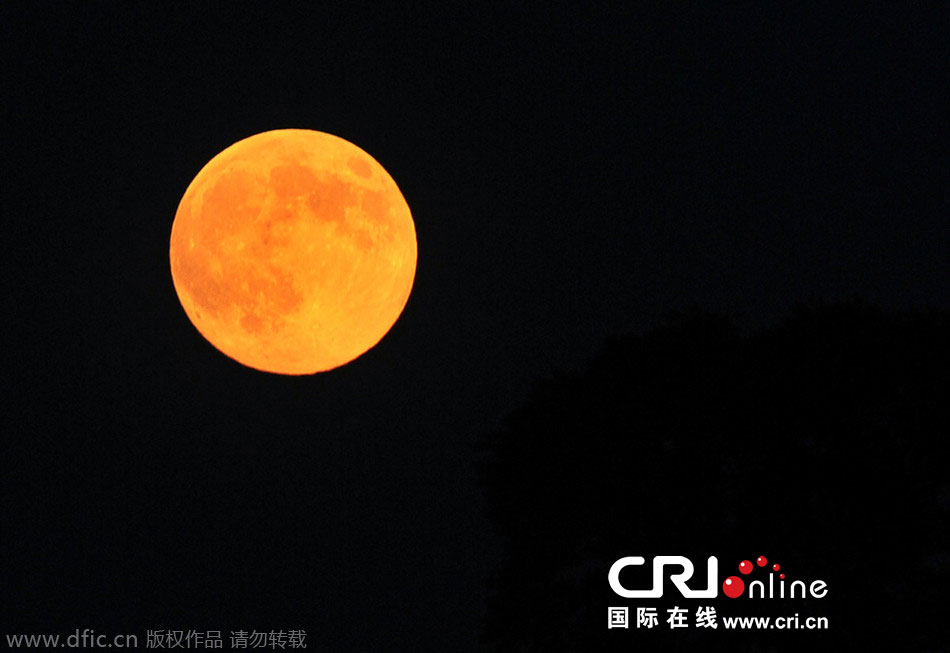 8月10日晚，一輪金燦燦的大月亮在遼寧省大連市東方升起。圖片來(lái)源：劉德斌/東方IC