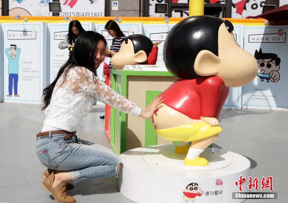 4月22日，游客與蠟筆小新合影。“蠟筆小新25周年紀(jì)念特展”日前在北京開展，吸引了不少市民游客。
