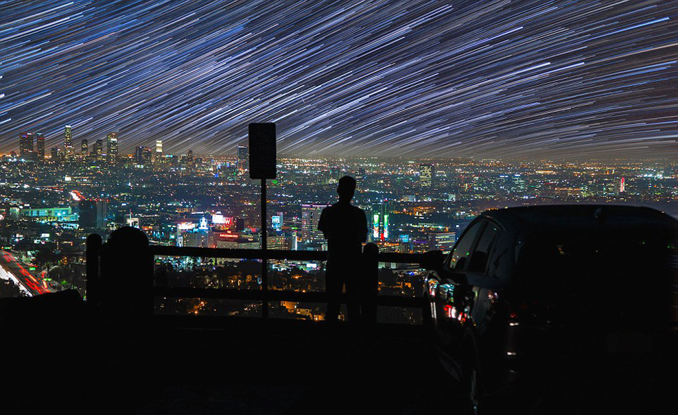 照片中，一名男子看著流星和隕星劃過天空。（網頁截圖）