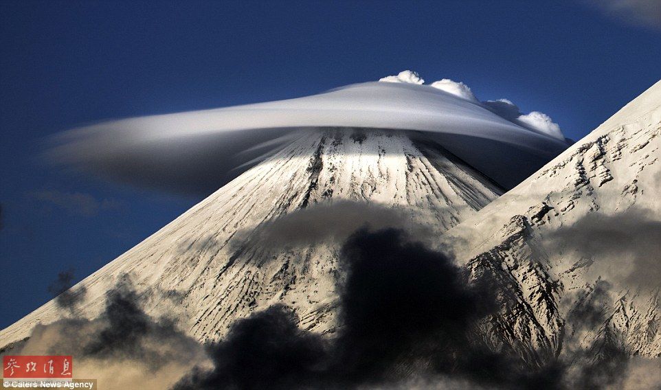 火山上籠罩著類似于外星飛碟形狀的云彩，場景猶如科幻大片。