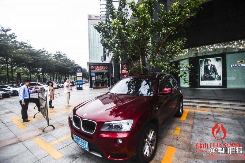 一輛停在停車位上的寶馬轎車，被墜落的樹枝砸中，樹枝徑直插入車內(nèi)，現(xiàn)場(chǎng)引發(fā)不少市民圍觀拍照。