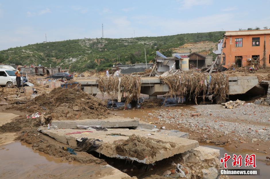 圖為洪水過后，坍塌的橋梁上遺落大量雜草。