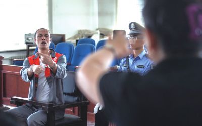 張志國在法庭上用手語回答提問。記者 蒲東峰攝