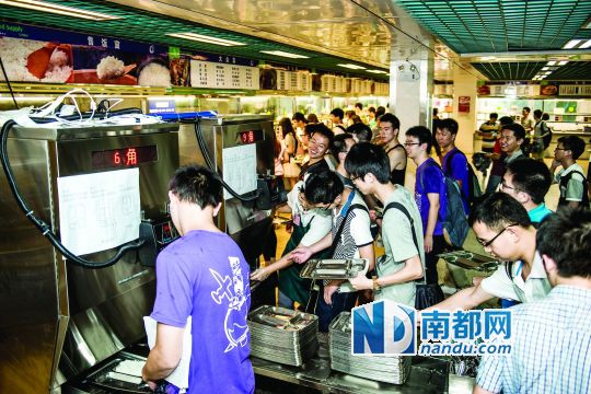 昨日，華南理工大學(xué)一食堂內(nèi)，學(xué)生們正在使用新安裝的自動(dòng)打飯機(jī)打飯。中新社發(fā)