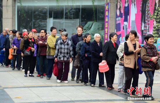 圖為10月28日，在江西九江市一家羊絨皮草服裝服飾博覽會(huì)現(xiàn)場(chǎng)，老人們正在頂著寒風(fēng)排隊(duì)等待領(lǐng)取10元代金劵。