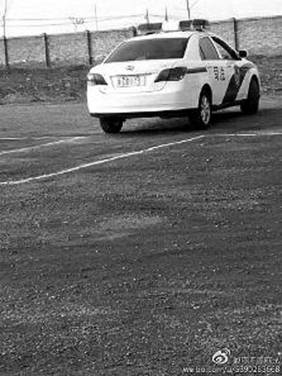 一輛車牌號(hào) 為“ 陜DD173”的制式警車停在一個(gè)劃著白線的場地上，車身標(biāo)有“司法”字樣