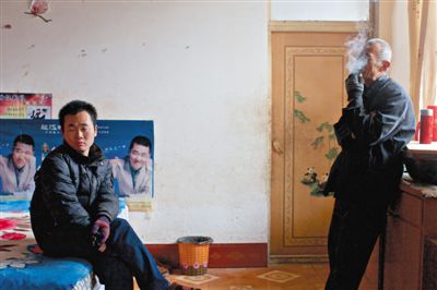 父親抽煙，兒子不語(yǔ)。逃跑的越南新娘，給袁迎賓父子帶來(lái)的是失落。新京報(bào)記者 周崗峰 攝