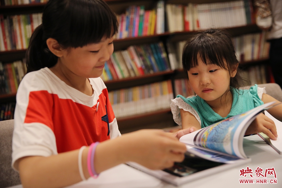 姐姐王藝茹，11歲，小學(xué)五年級學(xué)生；妹妹王有君，5歲：像喜歡看電視一樣喜歡看書。
