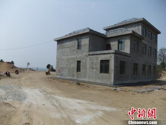 鴨河水庫庫區邊的新建別墅，一面墻上寫著“拆”，另一邊在加緊施工。吳揚　攝